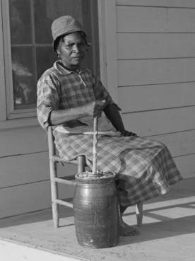 Gertrude Miller churning butter on the porch (Image: Marion Post Wolcott, 1939)